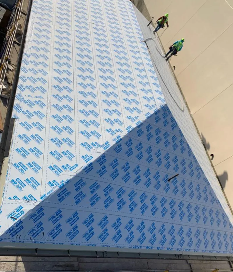 Professional roofers installing underlayment on a metal roof in Carteret